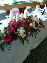 Cerise top table arrangement with candles